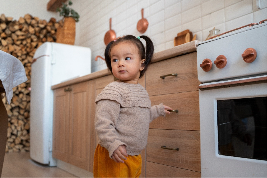 A child standing in a kitchen
Description automatically generated